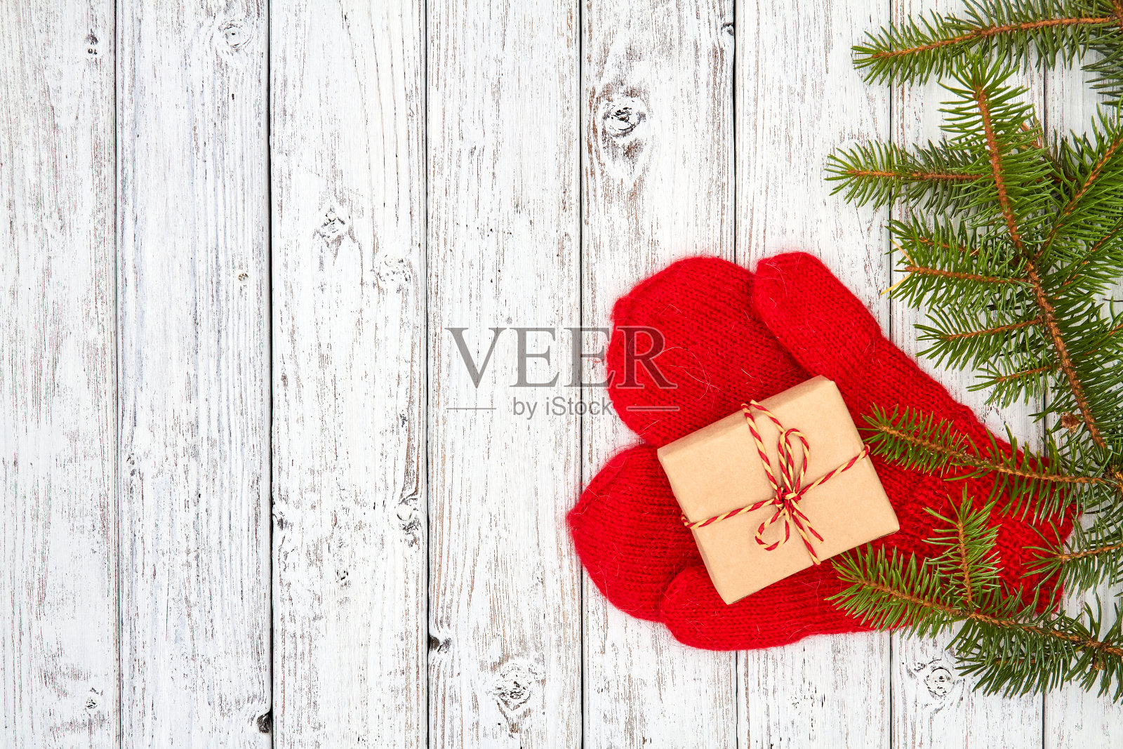 一个木制背景与圣诞节或新年礼盒上的红色手套和冷杉枝与拷贝空间照片摄影图片