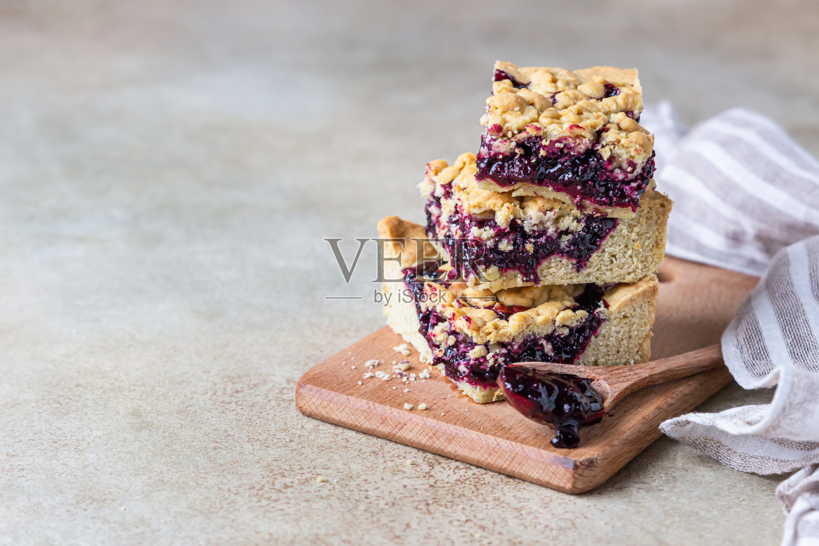 松脆饼棒与浆果果酱和碎木板，轻混凝土背景。自制的面包店。副本的空间。照片摄影图片