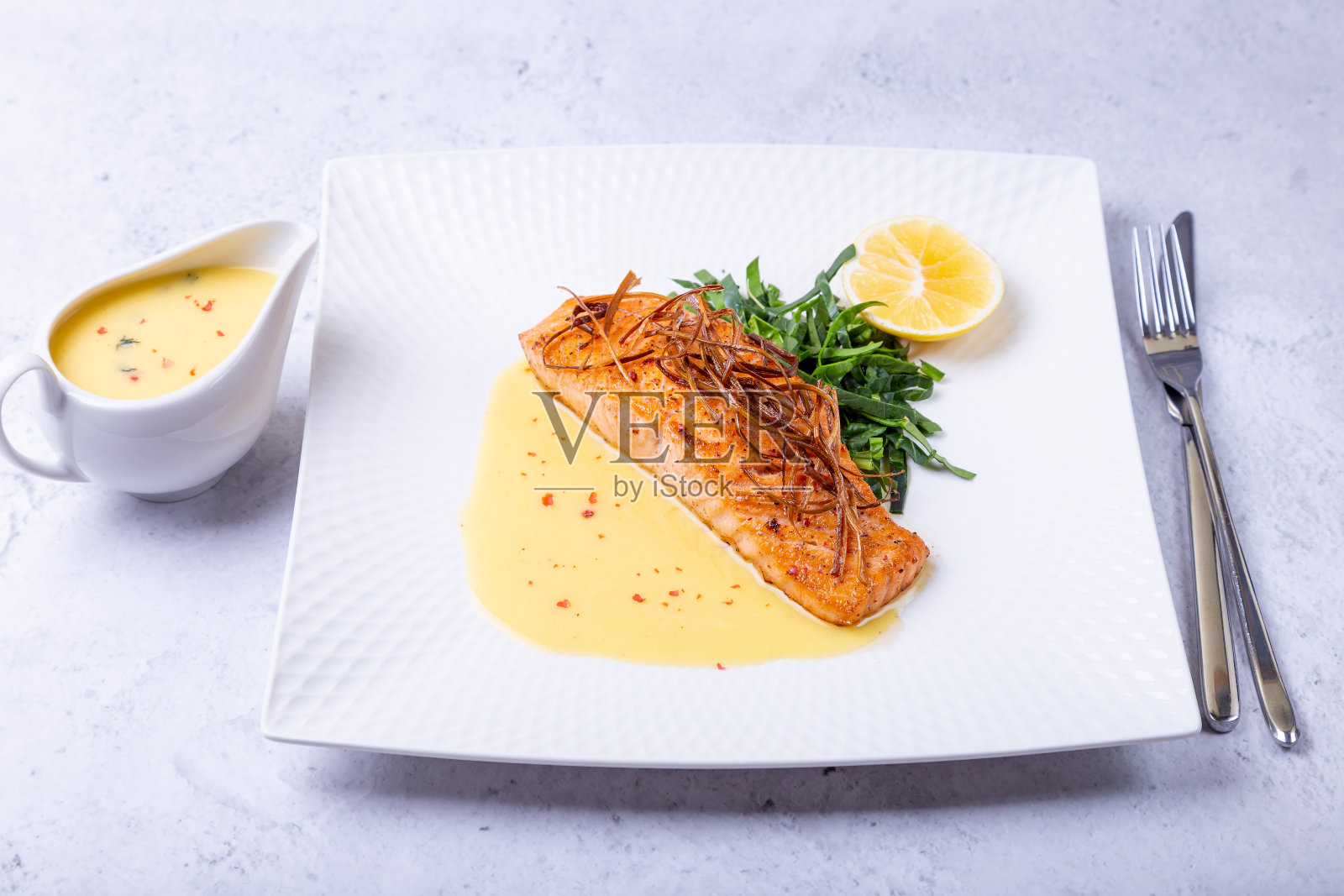 白椒酱三文鱼，菠菜和柠檬。装饰着韭菜。传统的法国菜。照片摄影图片