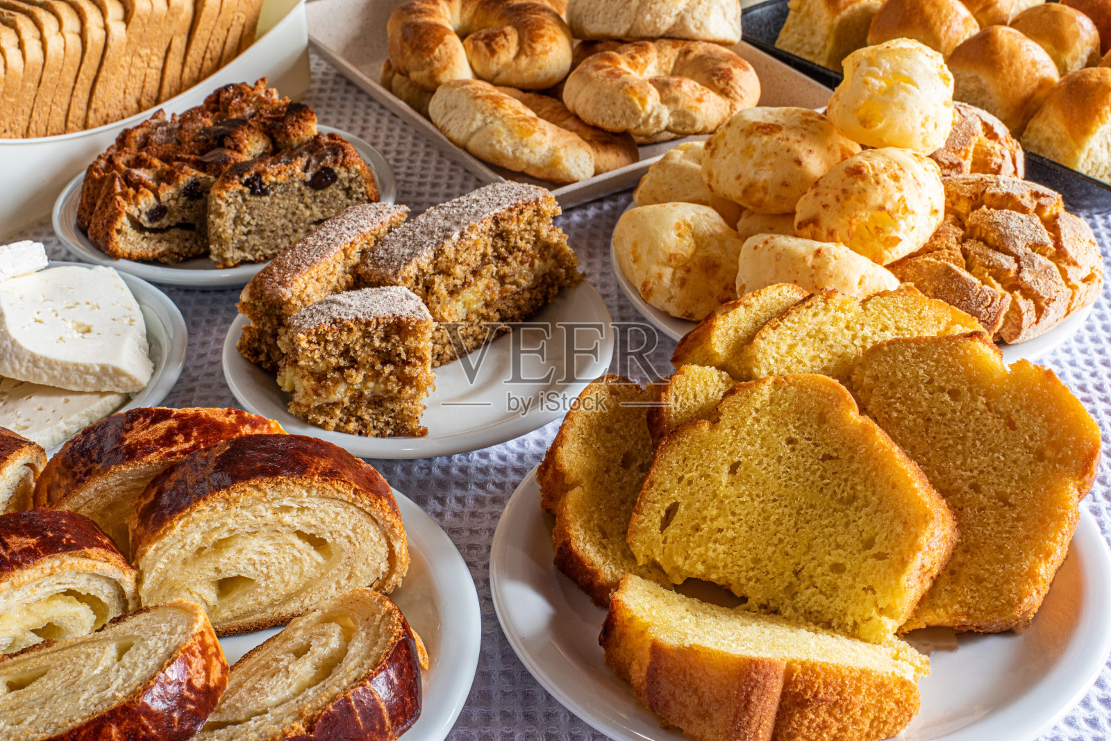 酒店的早餐桌上，有糖果、蛋糕、奶酪面包和面包。巴西米内拉美食。照片摄影图片