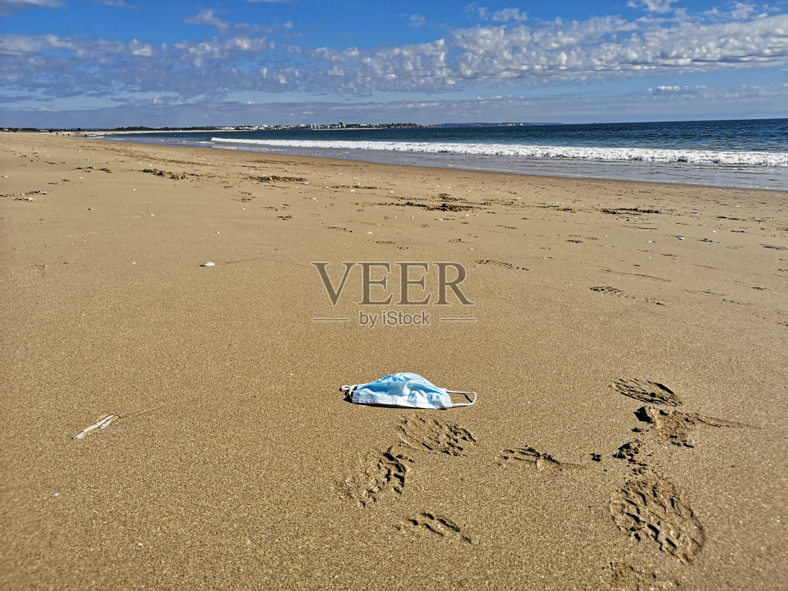 在葡萄牙拉各斯空荡荡的海滩上，一个Corona面具照片摄影图片