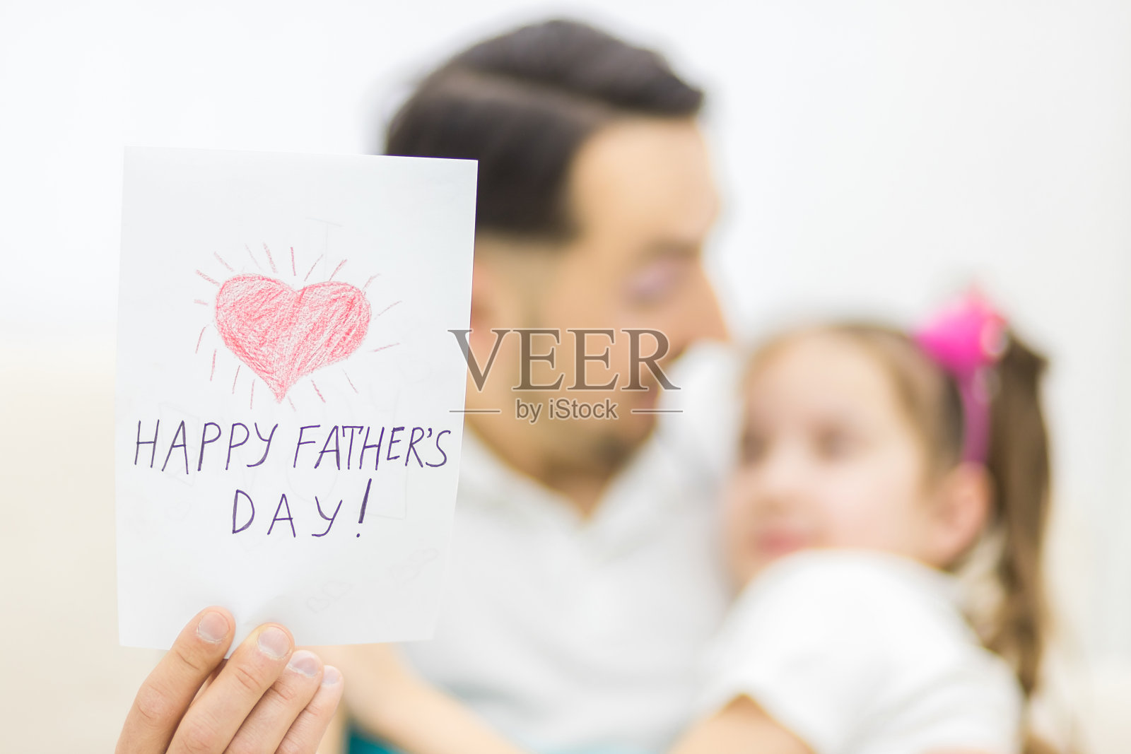 快乐的家庭，女儿在节日给爸爸一张贺卡。照片摄影图片