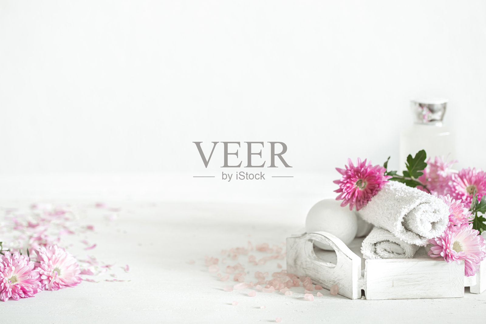 水疗组合与身体护理产品和鲜花在一个轻的背景复制空间。照片摄影图片