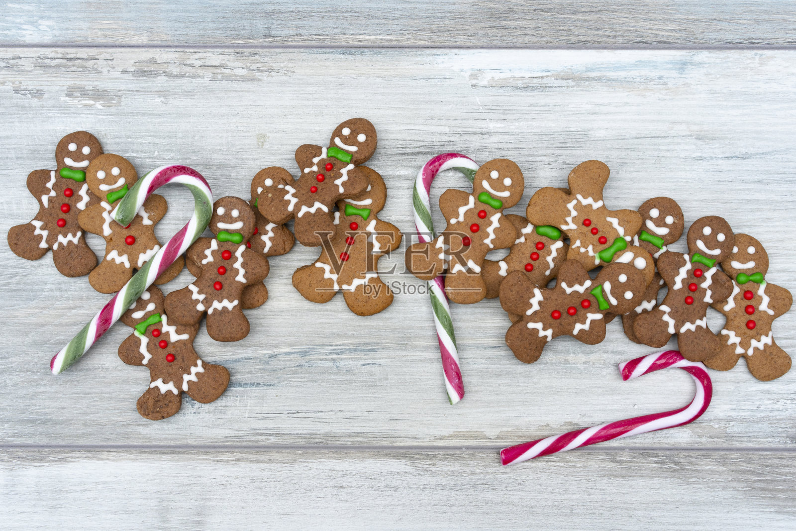 快乐的孩子从姜饼饼干在白色的乡村板。前视图。圣诞节烘焙概念。照片摄影图片