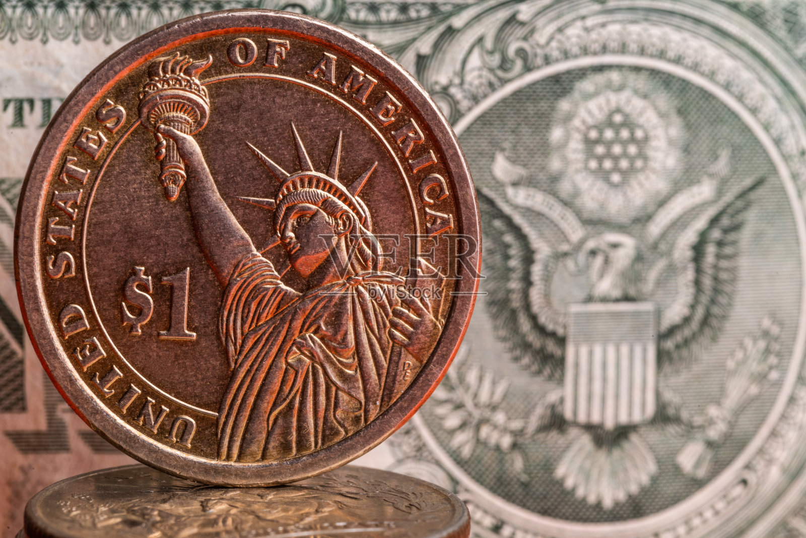 А一美元硬币的背景是一个美元纸币的碎片照片摄影图片