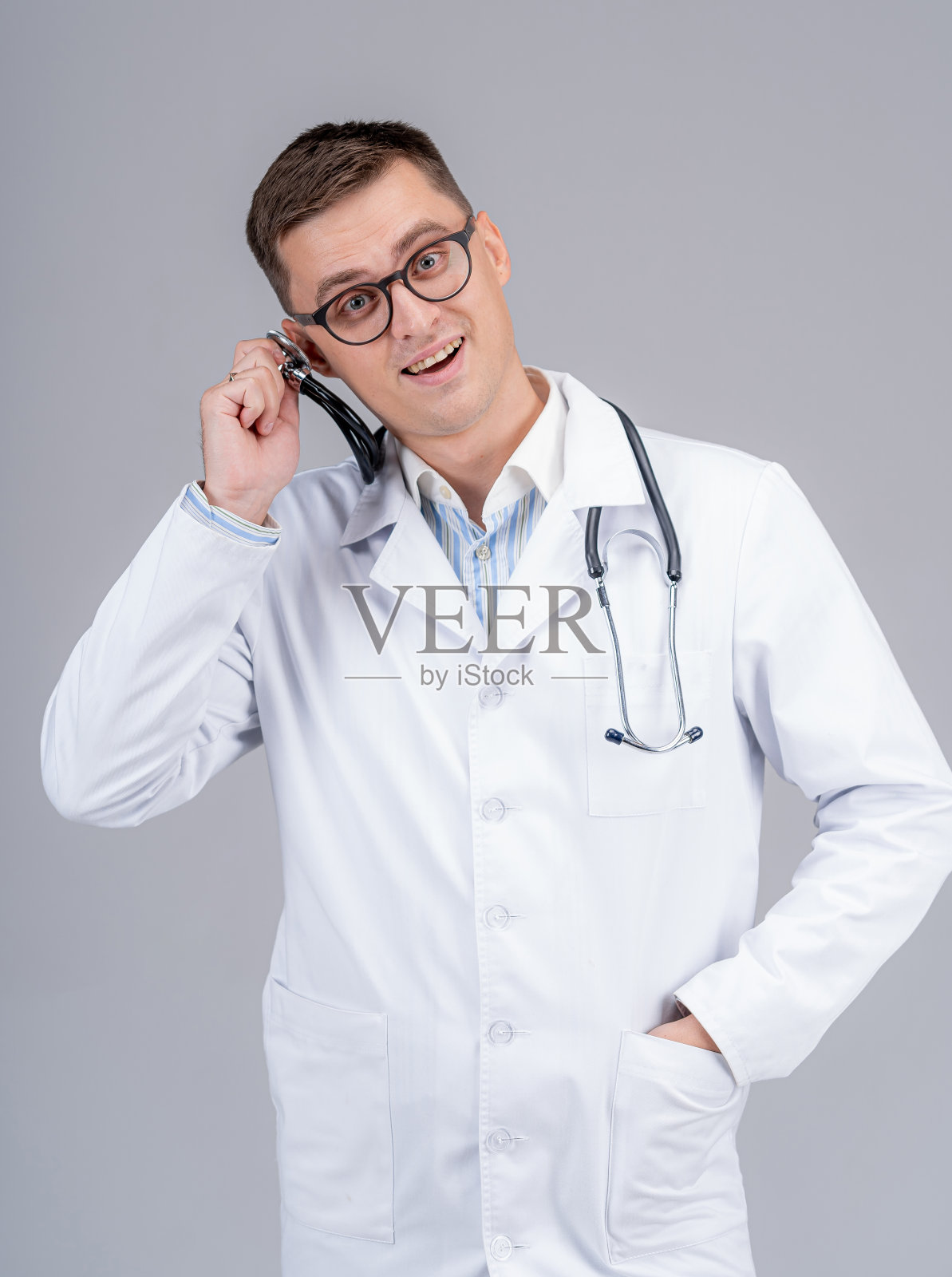 年轻英俊的医生在磨砂把耳镜。有趣的情绪。照片摄影图片