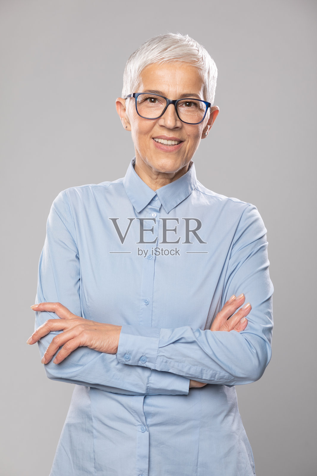 戴眼镜的高级女商人，蓝色衬衫，白色短发，戴眼镜照片摄影图片