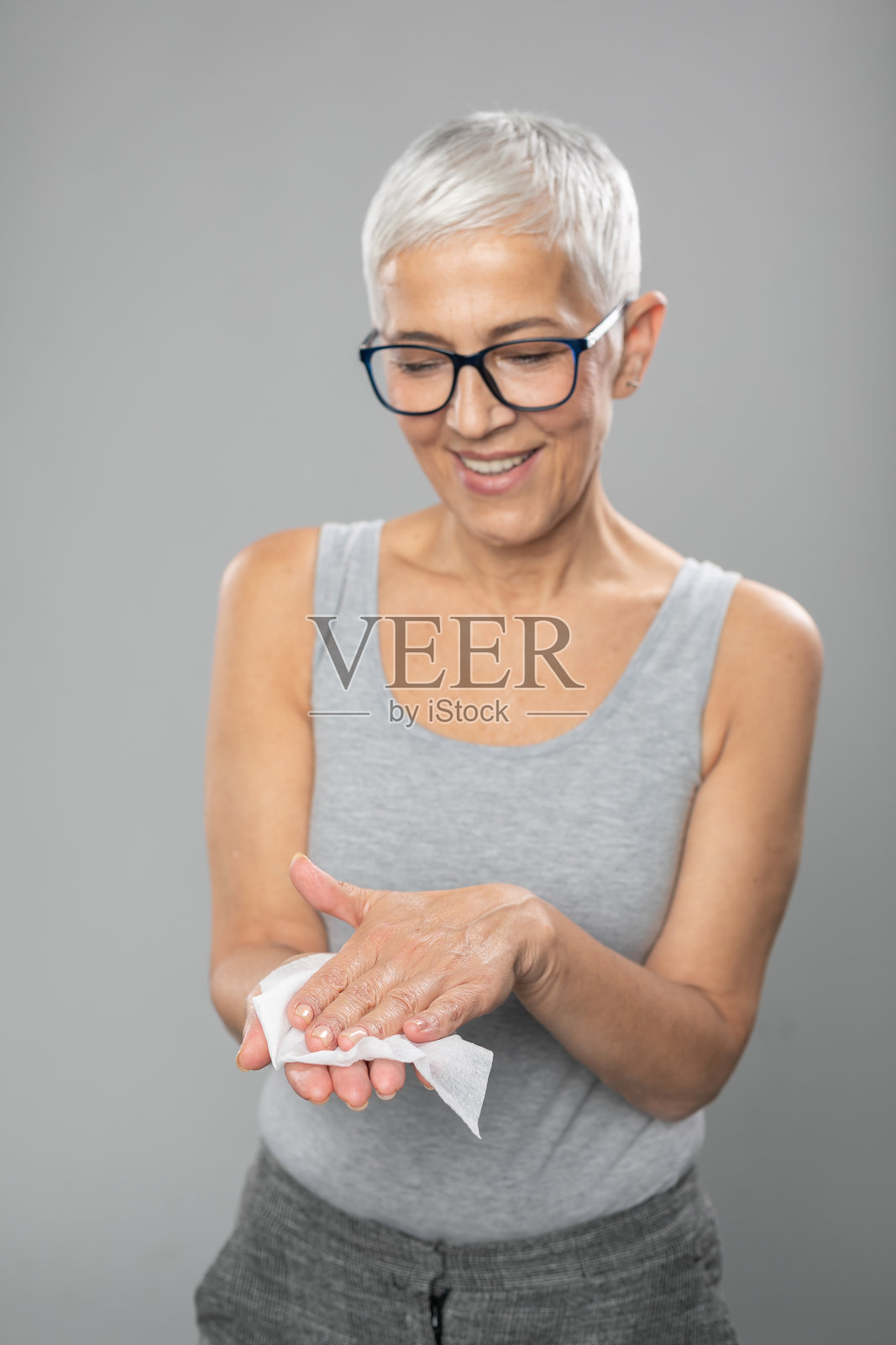 老年妇女用湿纸巾洗手-预防传染病照片摄影图片