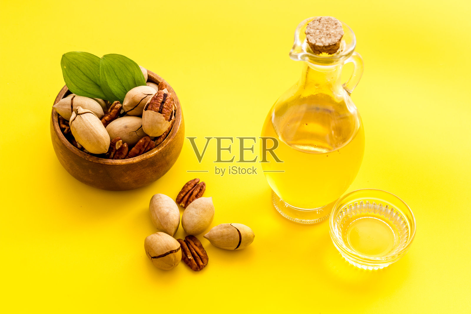 桌子上有一瓶山核桃油和坚果，靠近点照片摄影图片