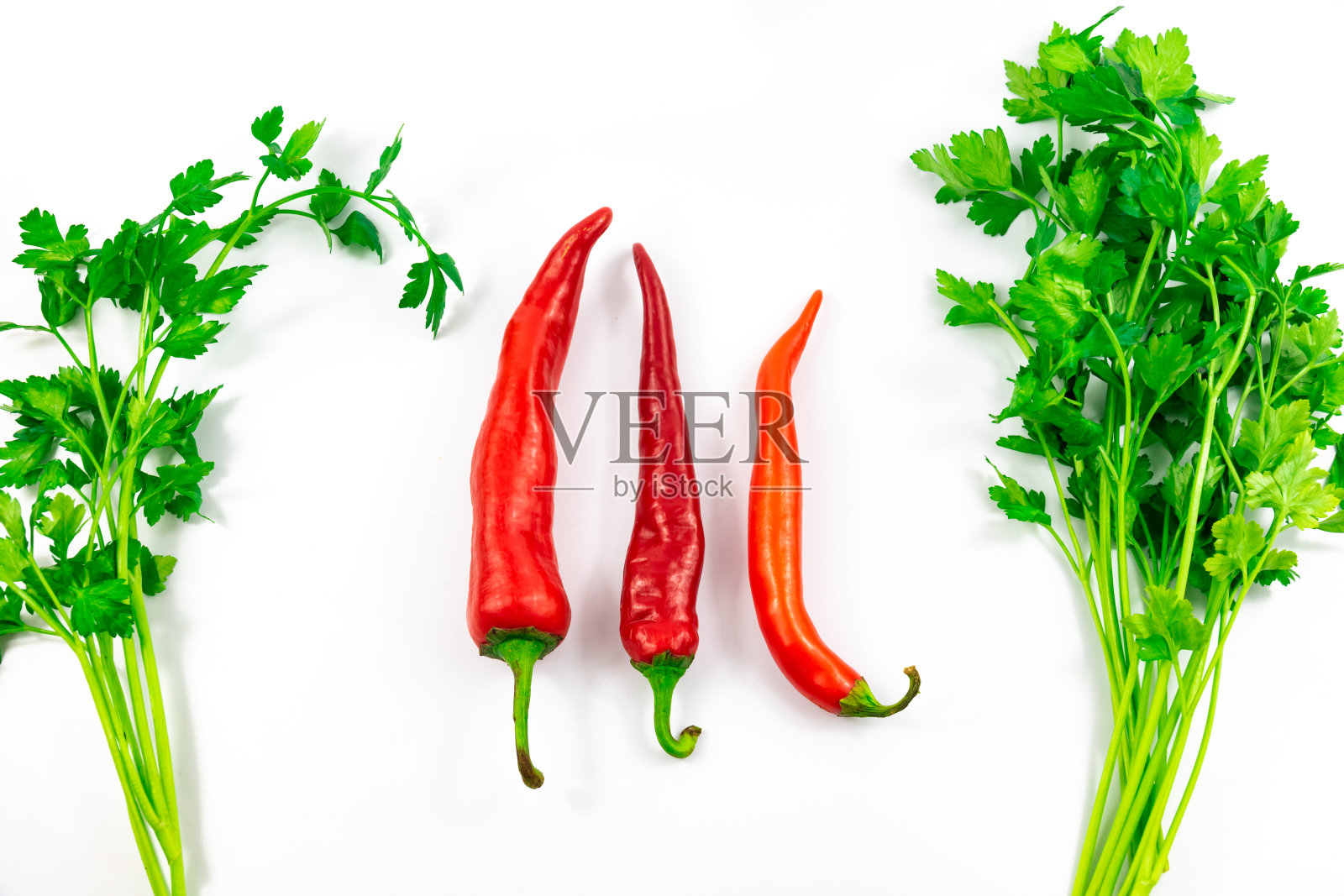 三个或三个以上不同大小的辣椒在白色和孤立的背景与药草，规模比较照片摄影图片