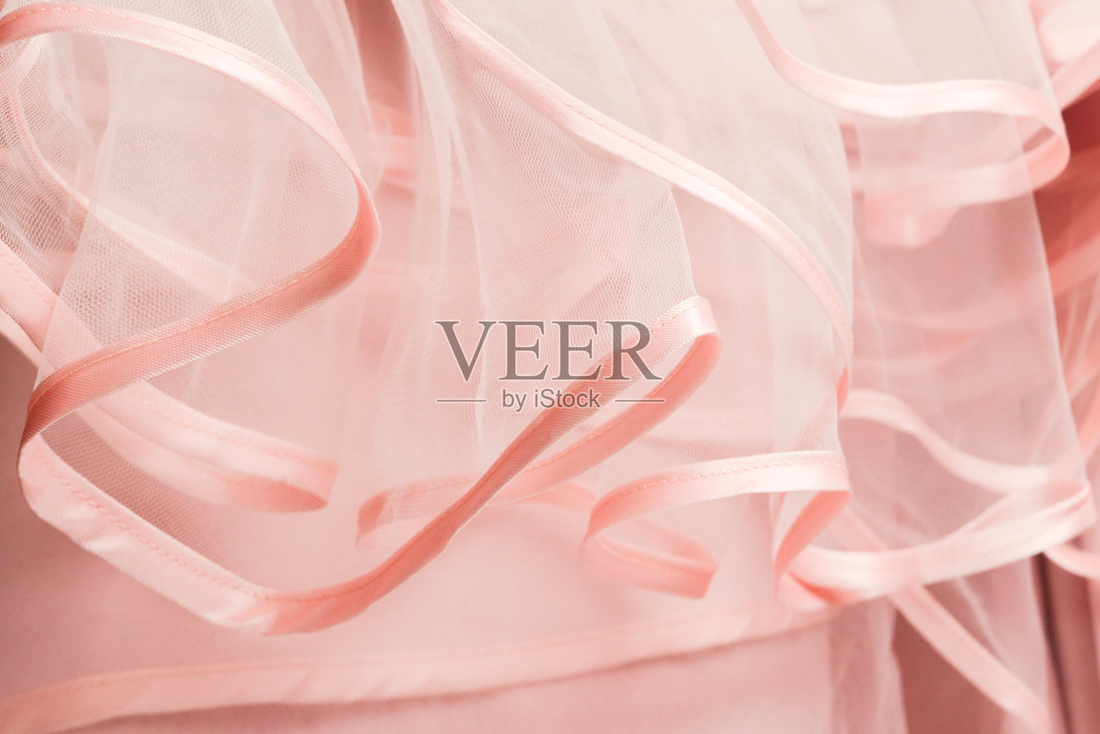 婚纱的细节。粉红色的婚纱褶边靠近。照片摄影图片