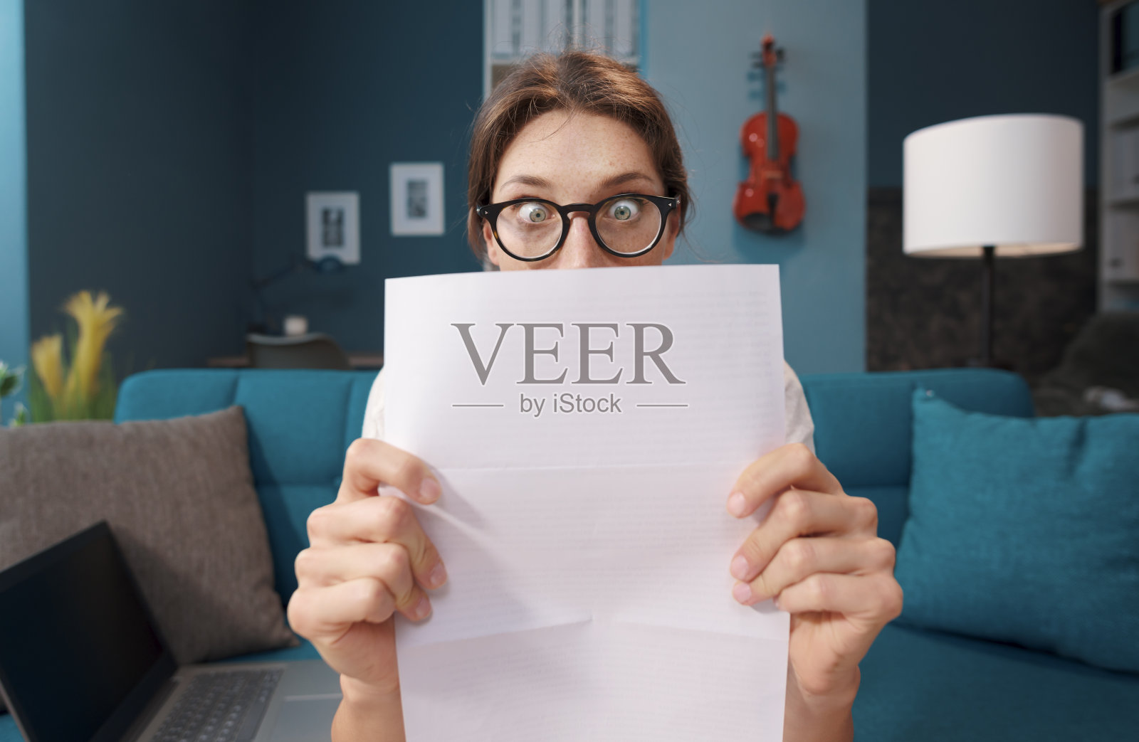 震惊的女人盯着她昂贵的账单照片摄影图片