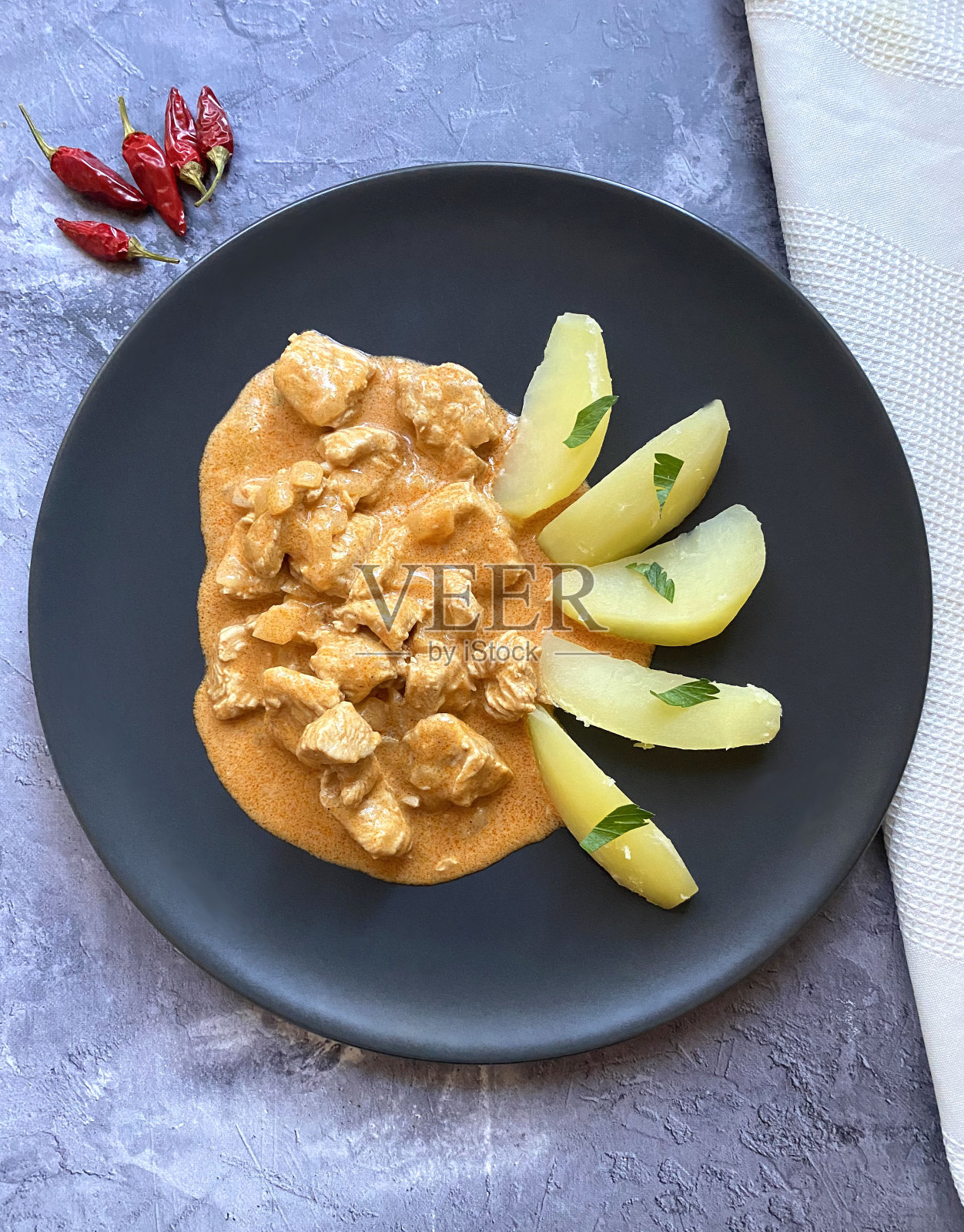 经典的炖牛肉配红辣椒酸奶油肉汁和煮土豆。照片摄影图片