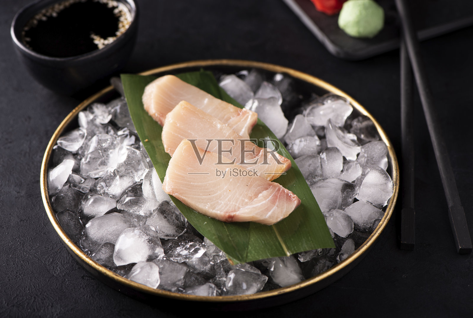 黑盘子里的冰鲱鱼生鱼片照片摄影图片