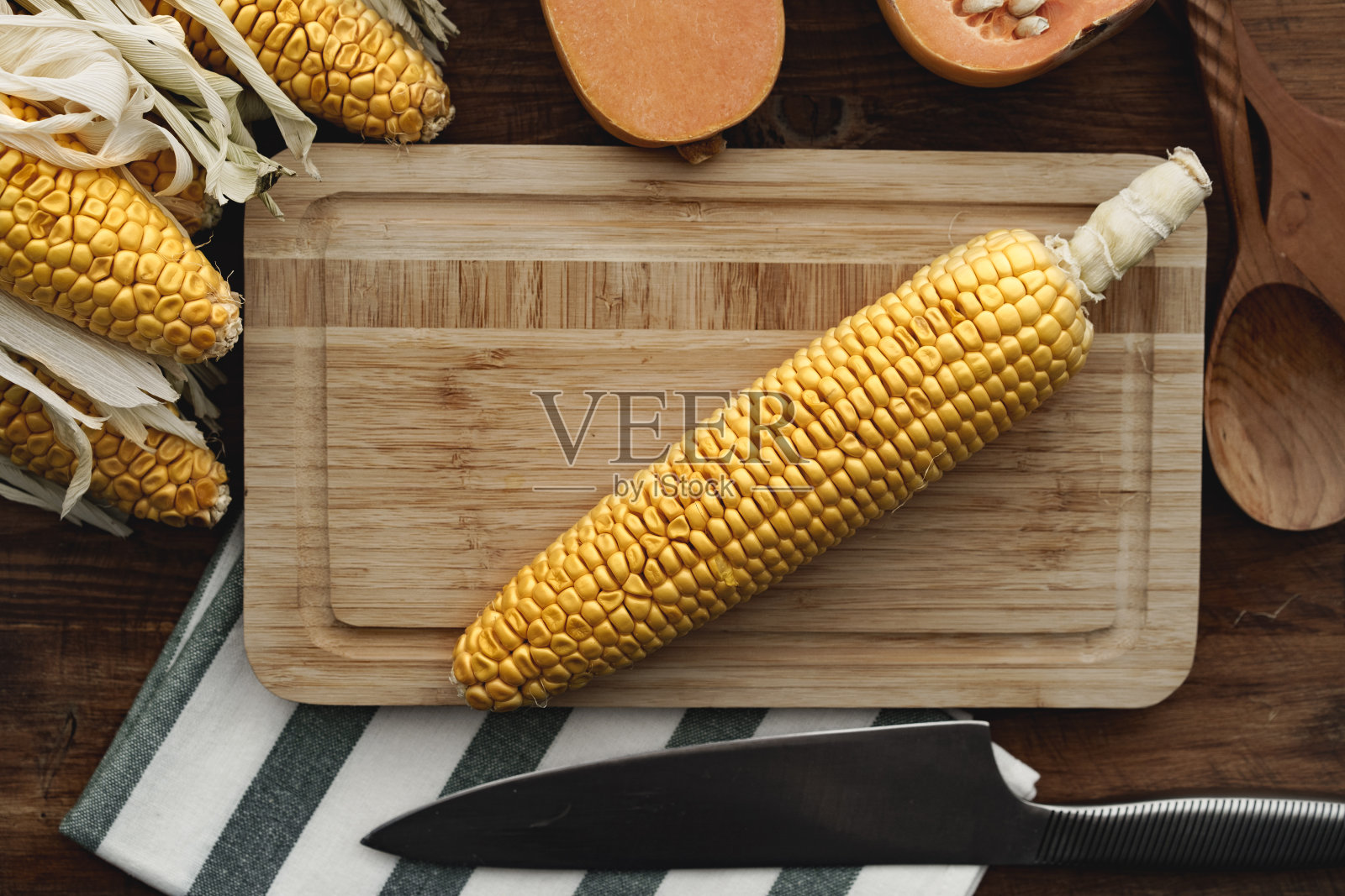 玉米芯和南瓜放在棕色的木板上照片摄影图片