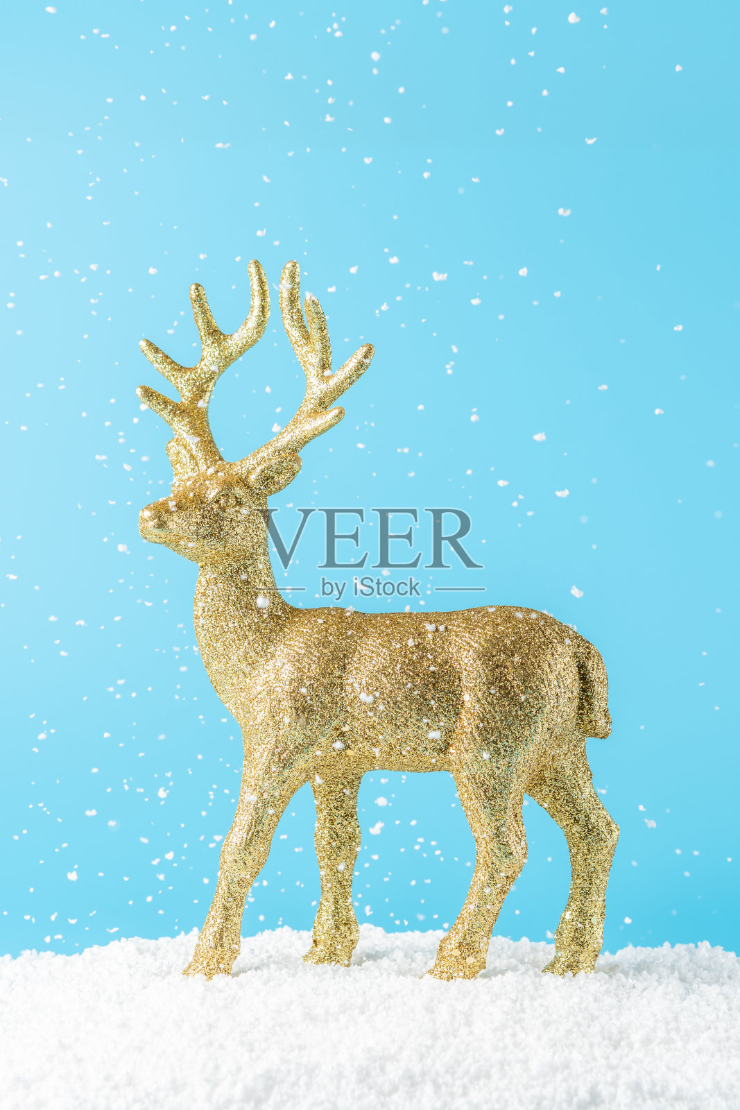 蓝色背景下的金色圣诞驯鹿。最小的新年概念。照片摄影图片