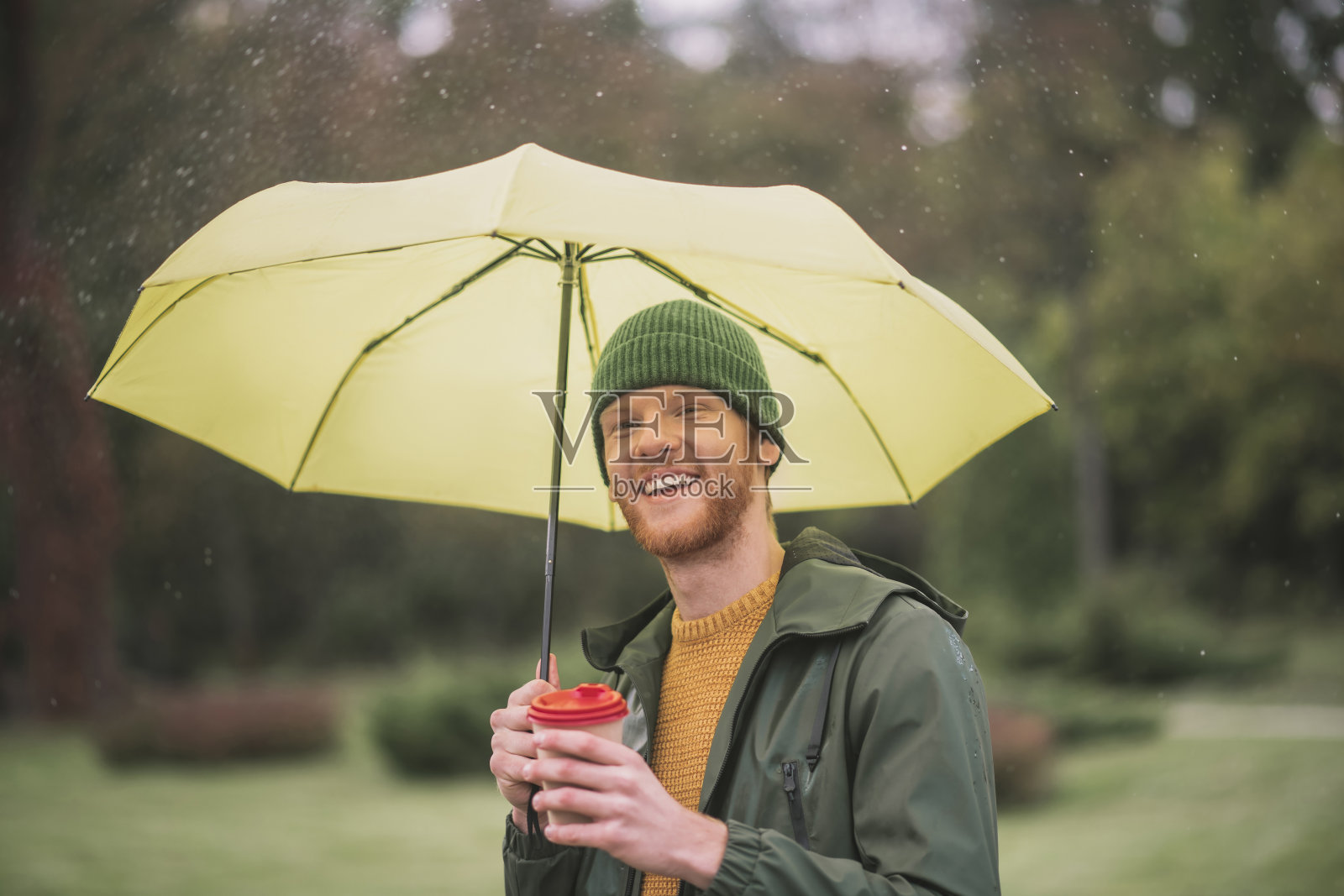 小胡子在黄伞下喝咖啡照片摄影图片