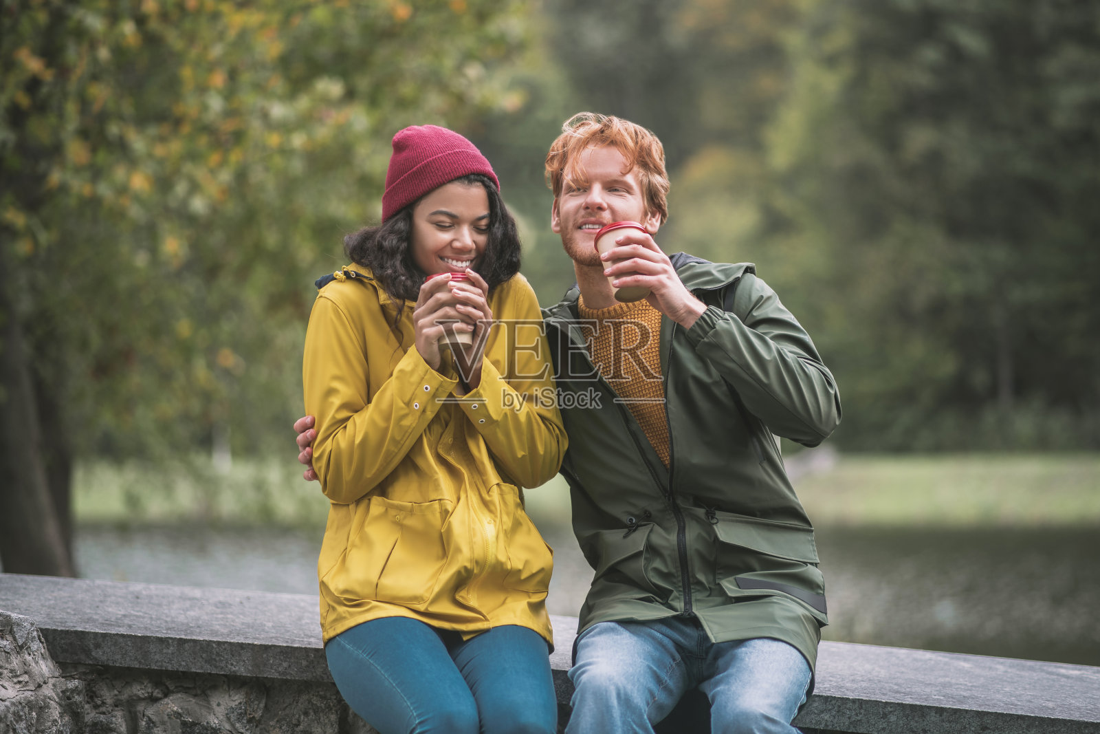 男人和女人在秋天的公园里喝咖啡照片摄影图片
