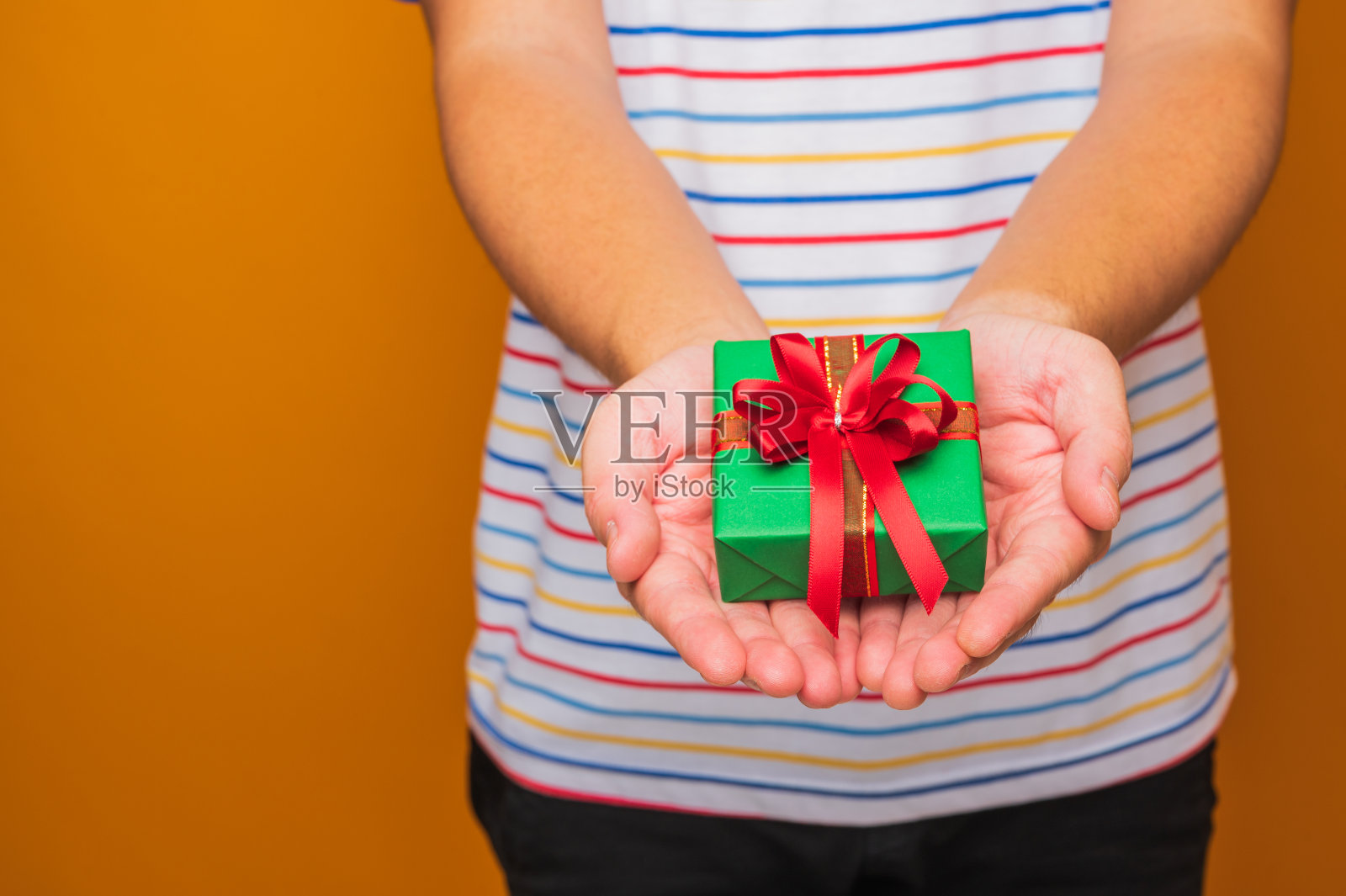 靠近男性的手拿着礼物盒显示到相机。圣诞快乐，新年快乐。照片摄影图片