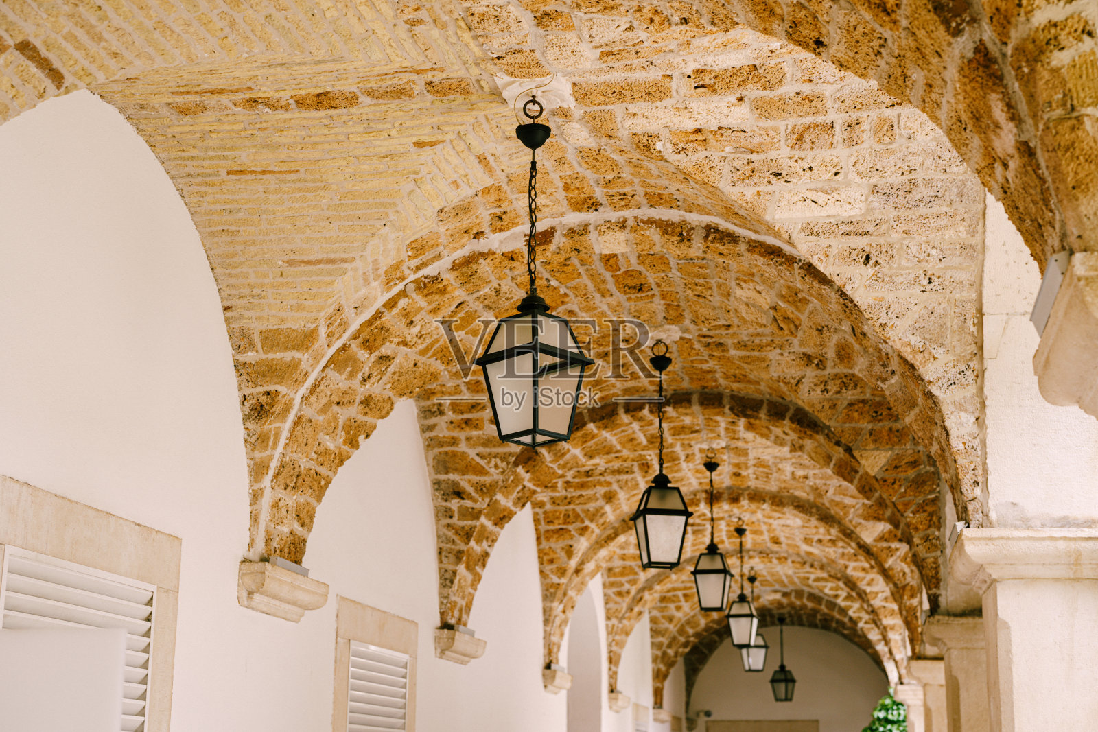 天花板上的拱形洞口悬挂着灯。照片摄影图片