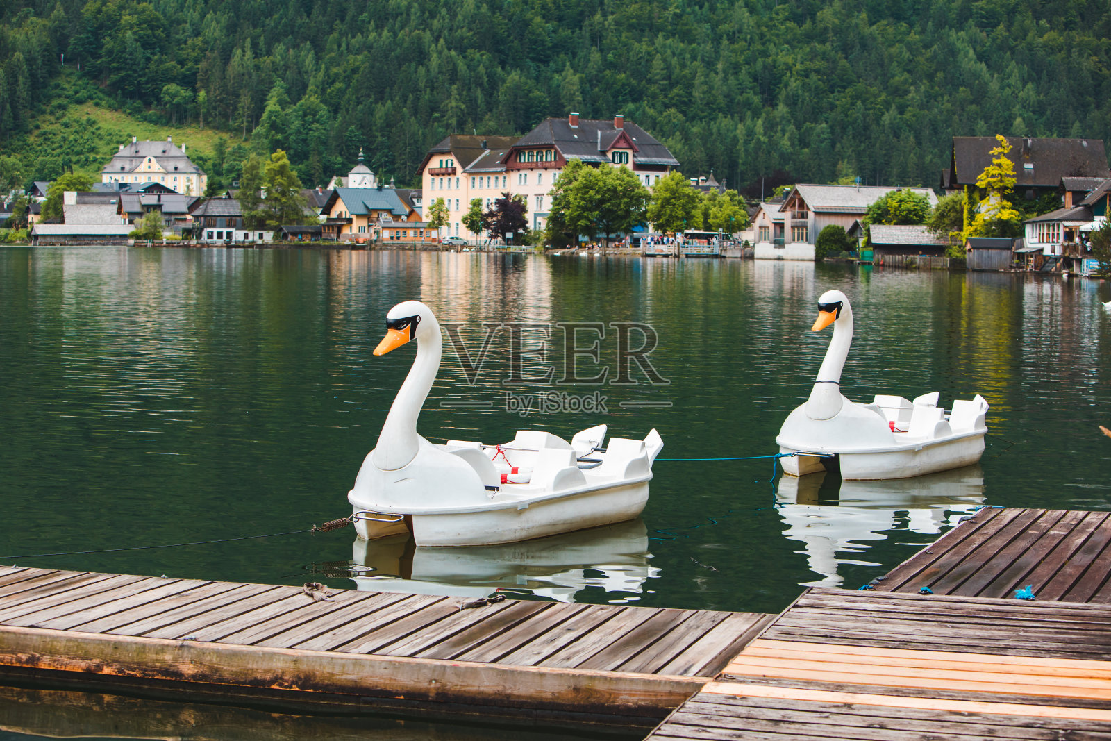 高山中天鹅形湖上的双体船照片摄影图片