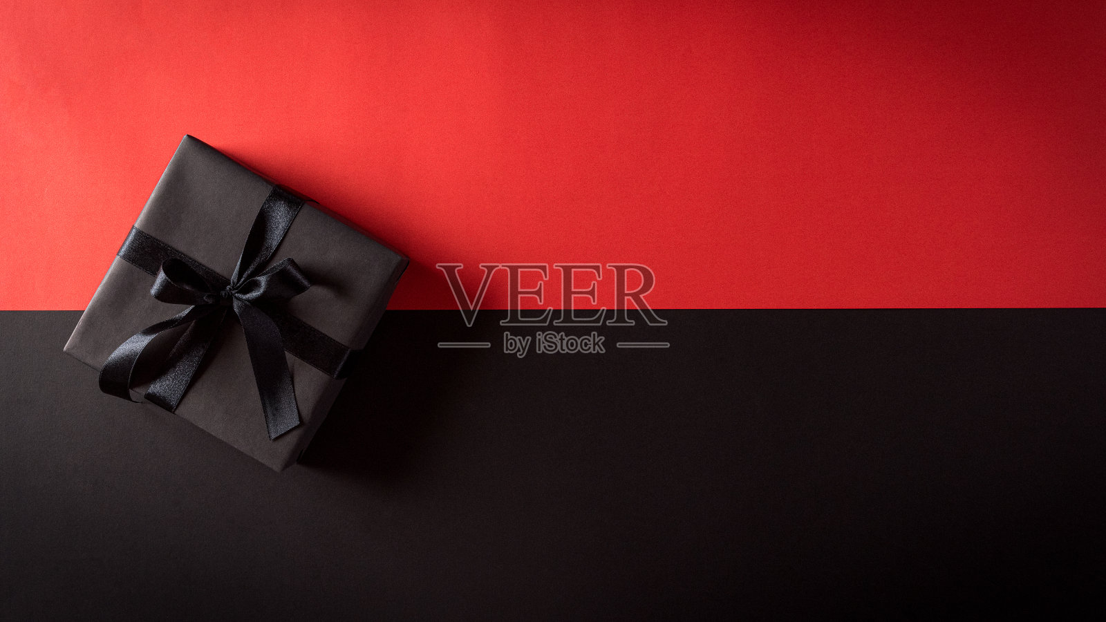 顶视图的圣诞盒子与黑色的丝带和红色的背景与文本的复制空间。“黑色星期五”组成。照片摄影图片