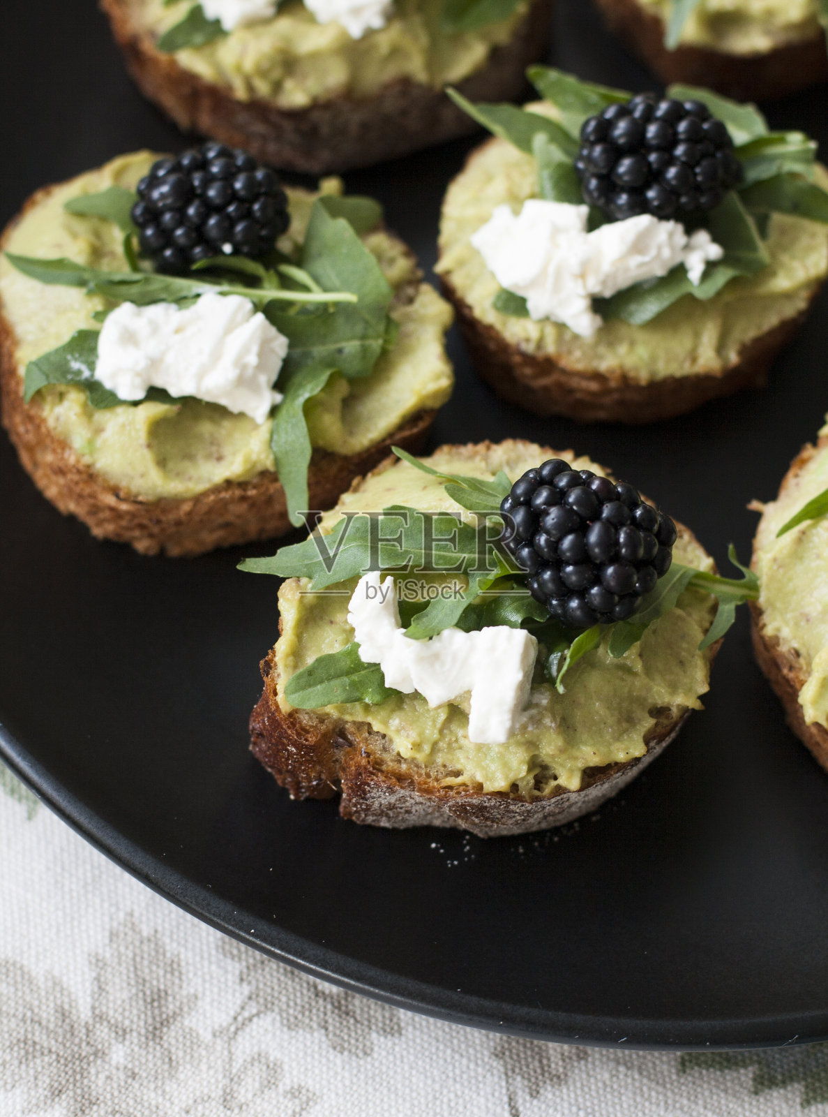 美味的午餐:奶油芝士鳄梨三明治，黑莓和芝麻菜。照片摄影图片