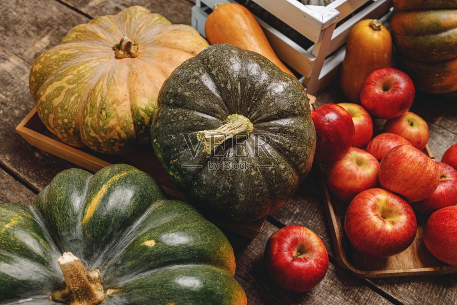 木制背景上的南瓜和红苹果照片摄影图片