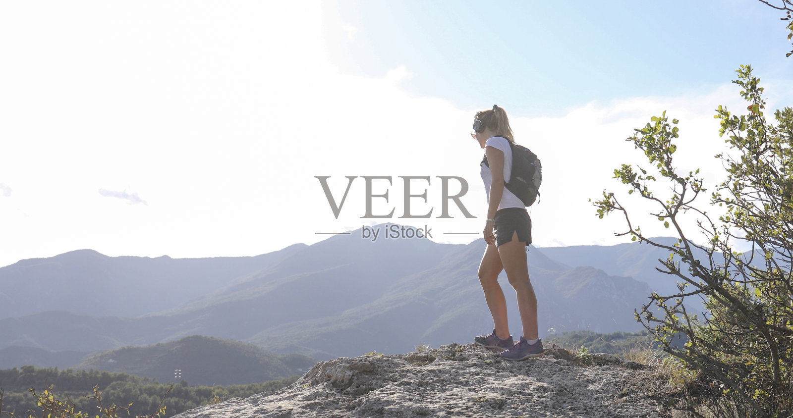 一名年轻女子在日落时分沿着山脊徒步照片摄影图片