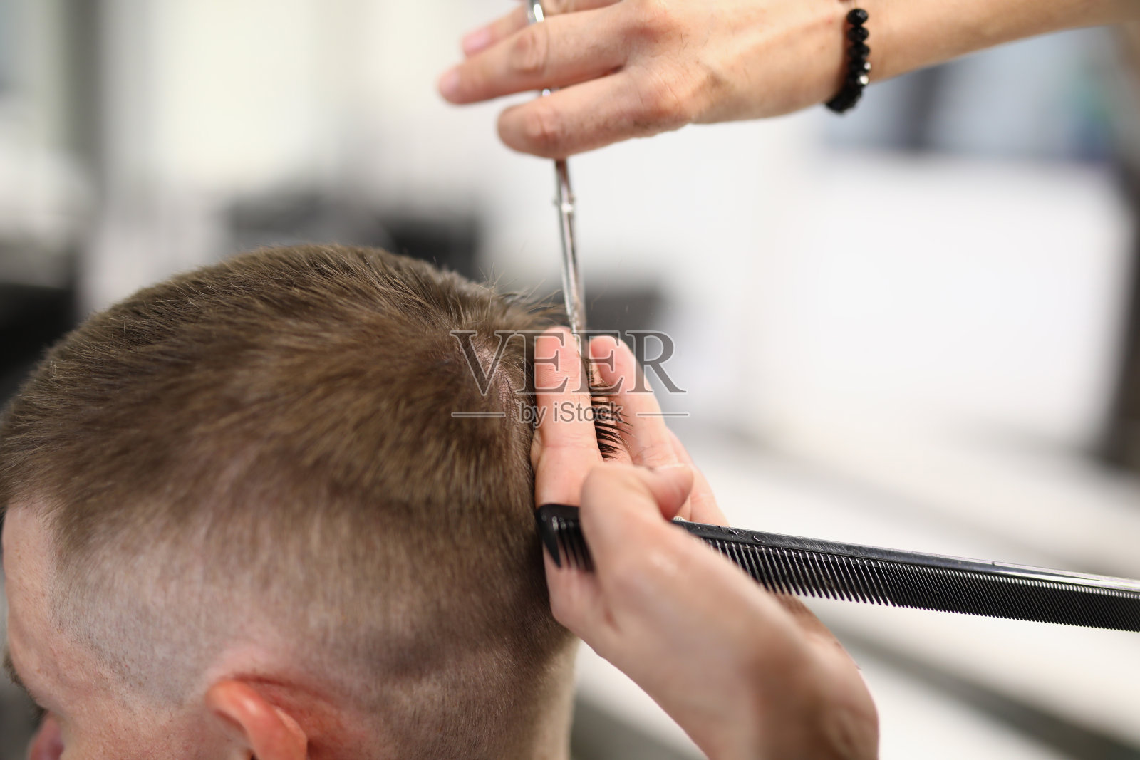 师父的头拿着梳子，用剪刀剪头发。照片摄影图片