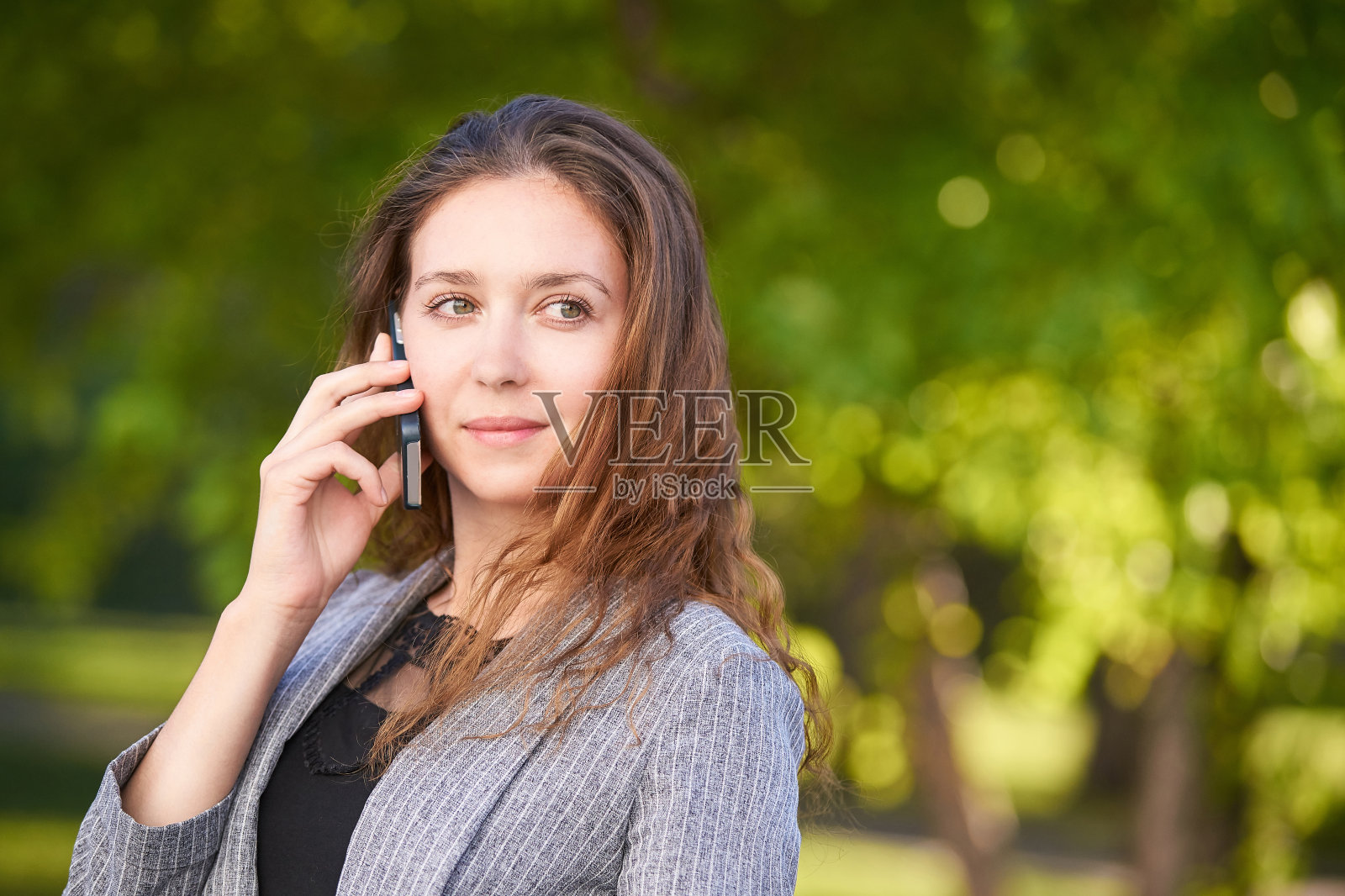 年轻女孩打电话。户外工作照片摄影图片