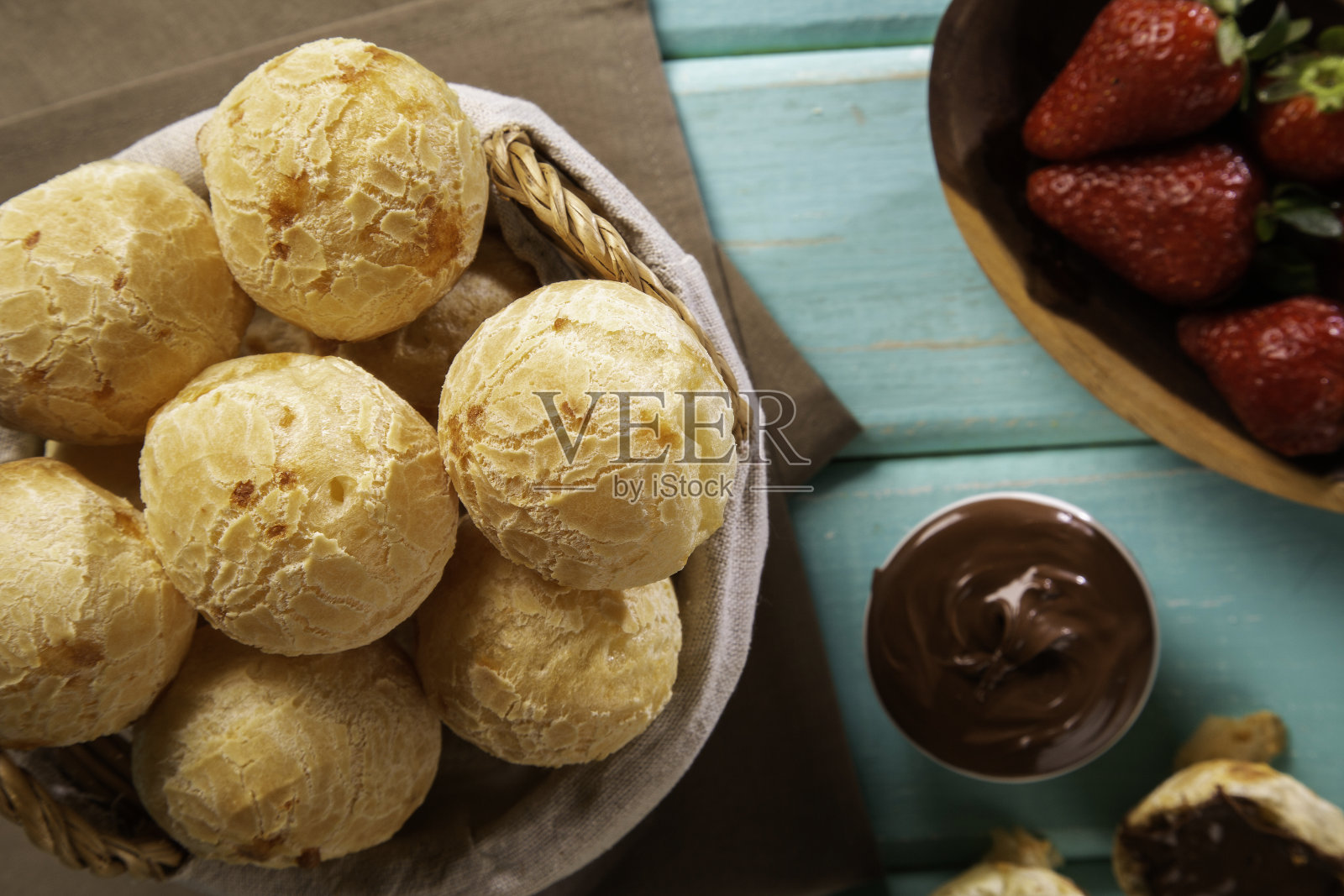 巴西小吃奶酪面包塞满了巧克力和草莓水果在绿色的木材背景。照片摄影图片