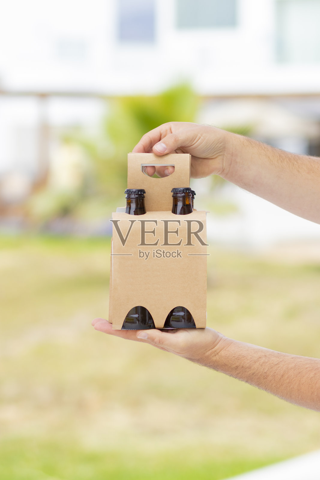 拿着4包啤酒在海滩上庆祝照片摄影图片