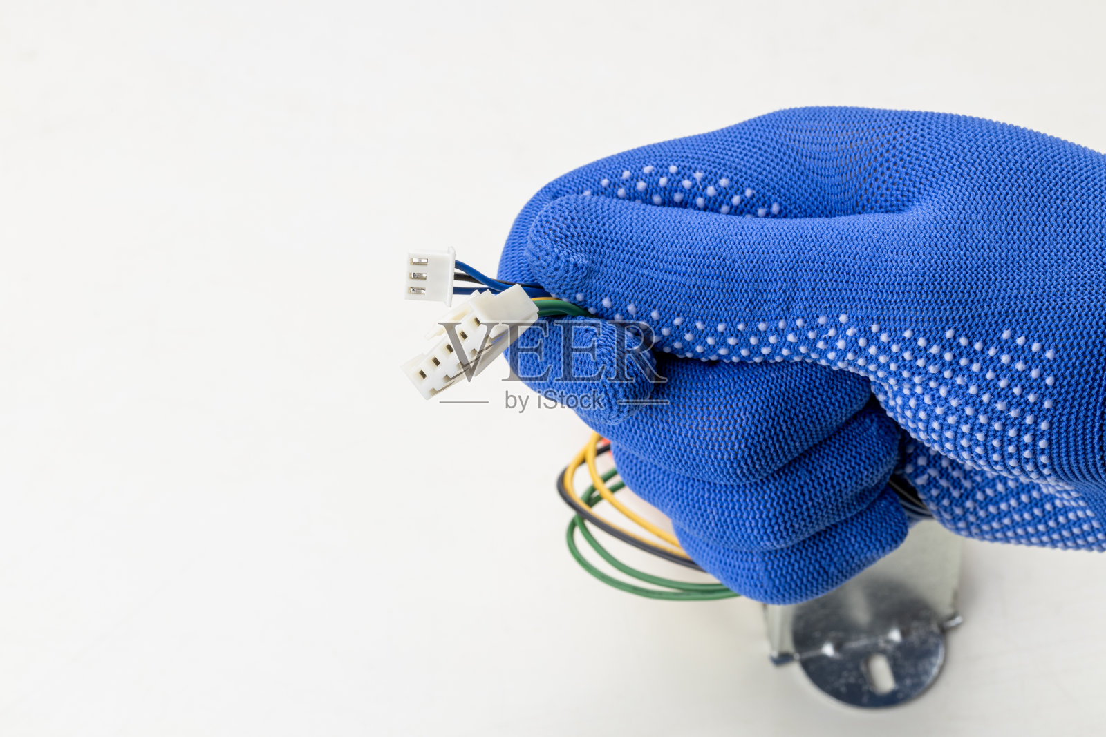 技术工人手中拿着无线电变压器，隔离在白色背景上。电器元件行业概念。影棚拍摄照片摄影图片