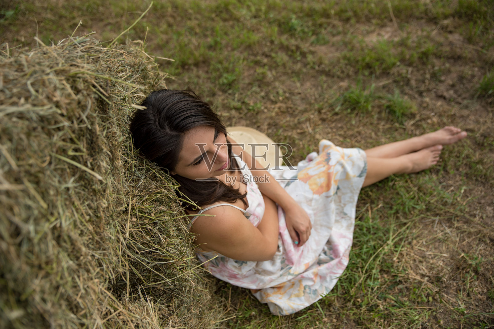 村里的女孩坐在草地上照片摄影图片