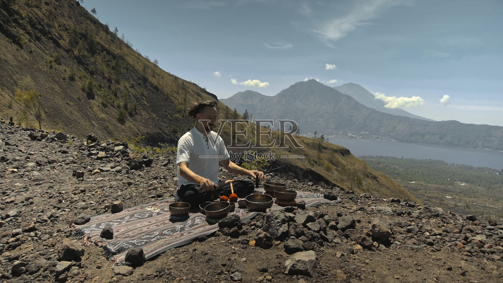 在山顶演奏铜磬的亚洲男子照片摄影图片