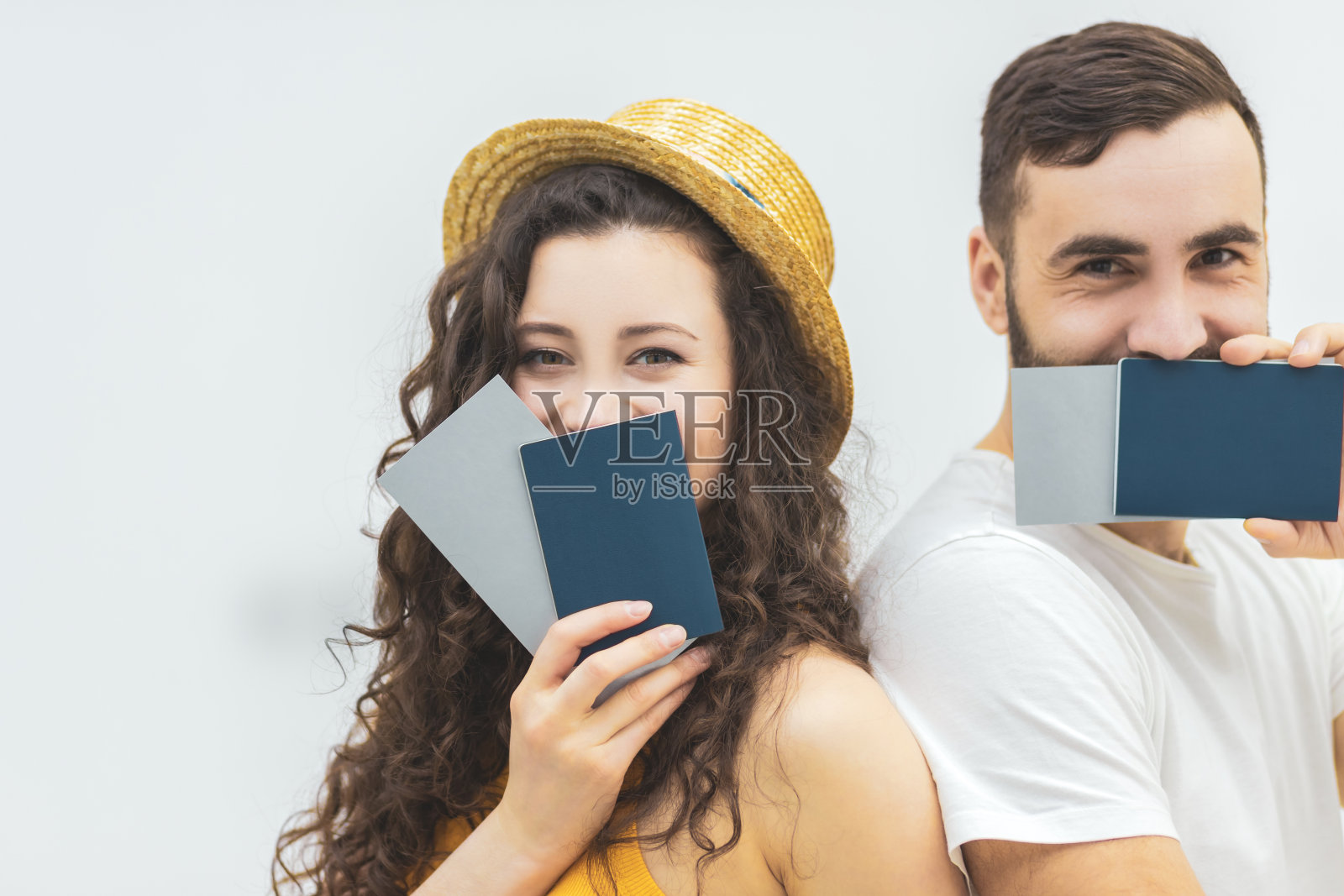 年轻女子和丈夫持有护照作为旅行证件与有趣的外观。照片摄影图片