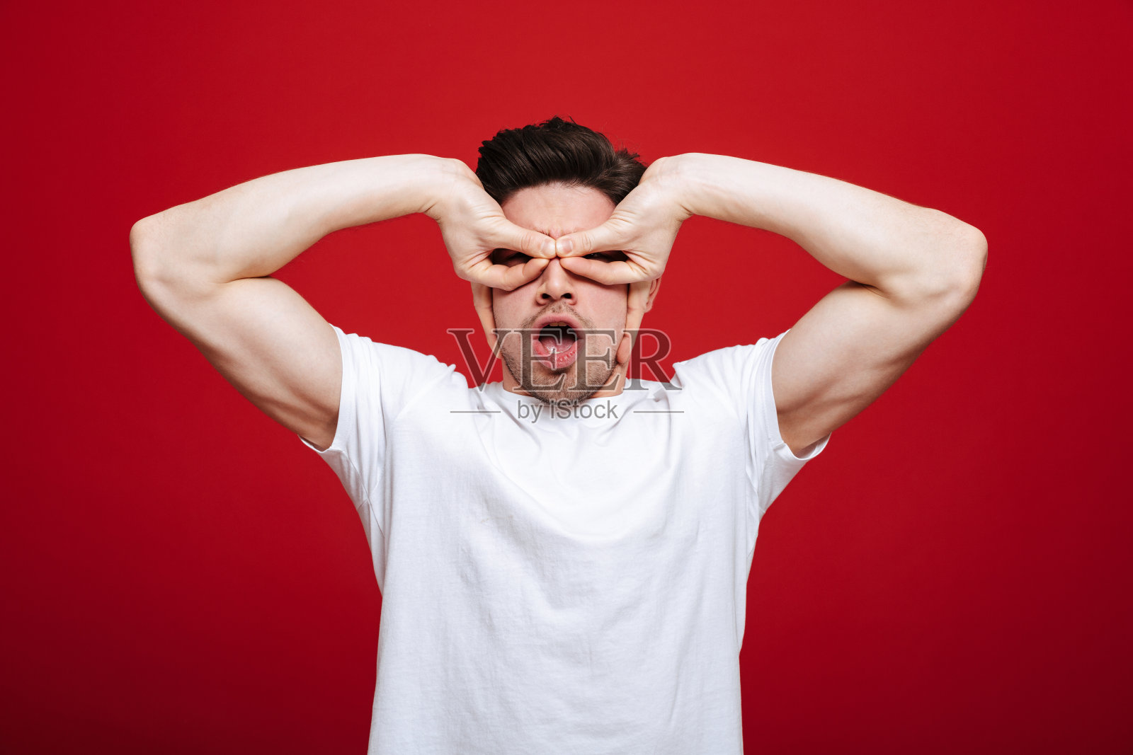 一个穿着白色t恤的有趣的年轻人的肖像照片摄影图片