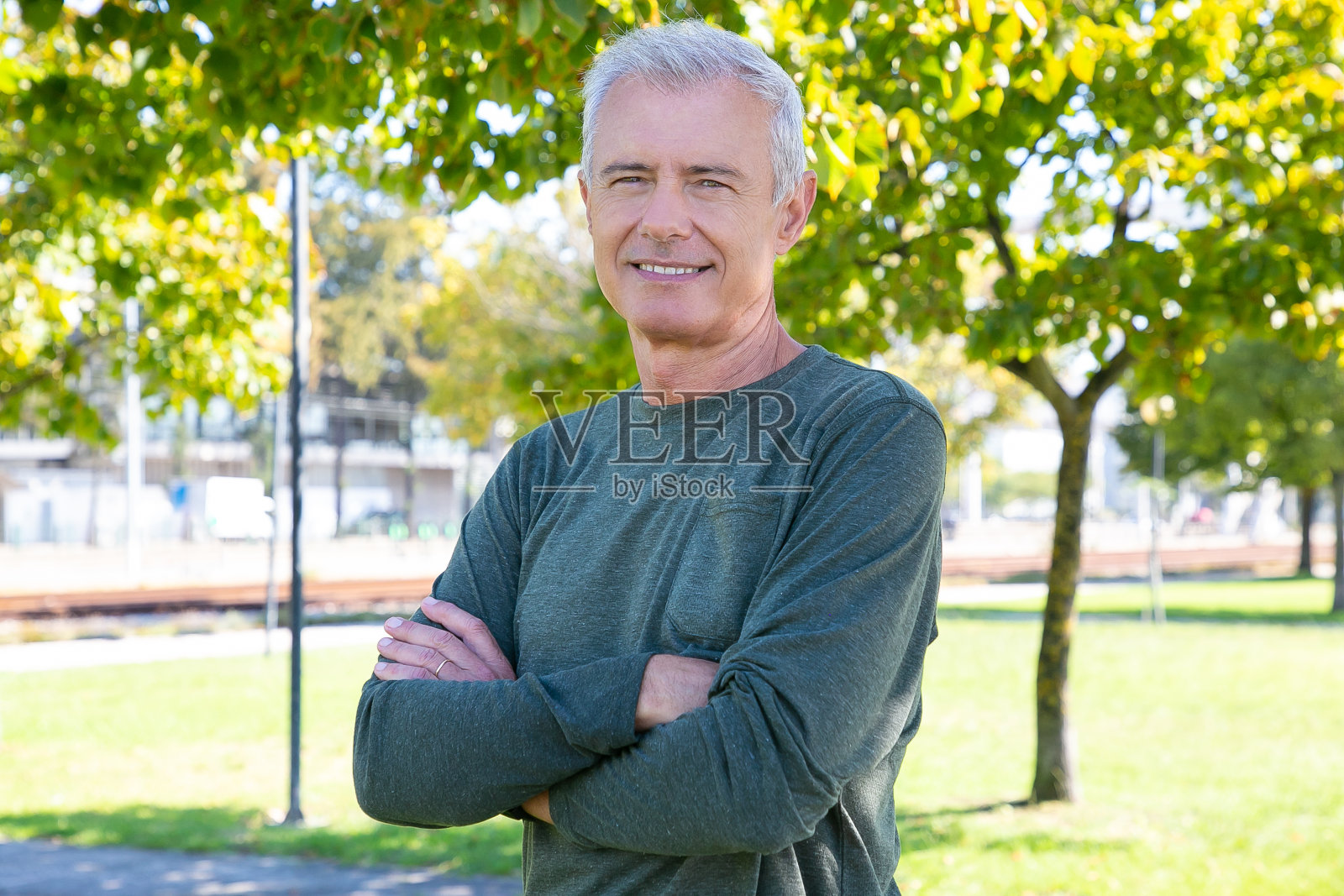 幸福成熟的男人抱着双臂站在外面照片摄影图片