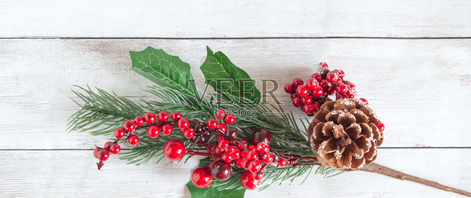圣诞装饰由云杉树枝与红色浆果和棕色天然松果在一个轻木制背景。文字空间，俯视图，平放。从底部开始分支照片摄影图片