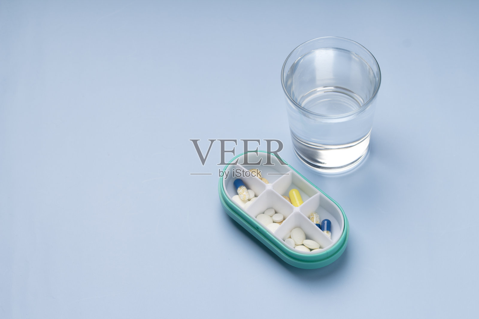 药丸计划盒与药片和一杯水，蓝色医疗背景。本空间照片摄影图片