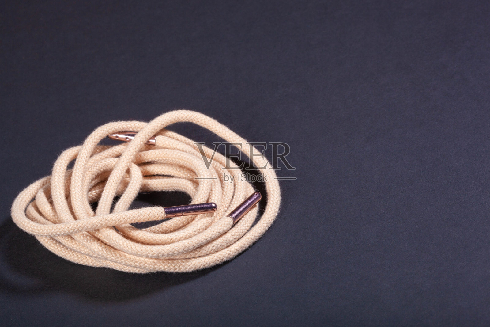 新的米色鞋带与金属花边帽在黑色的背景照片摄影图片