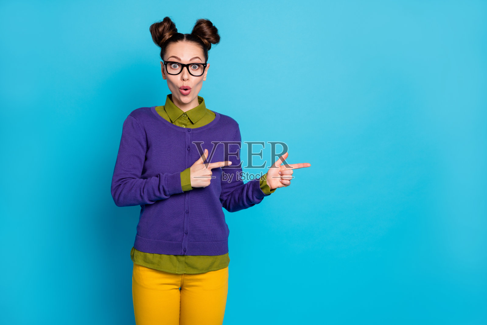 她的肖像，她漂亮迷人，漂亮愉快的棕色头发的女孩展示广告广告孤立在明亮生动的照耀，充满活力的蓝色，绿色，蓝绿色，蓝绿色的背景照片摄影图片