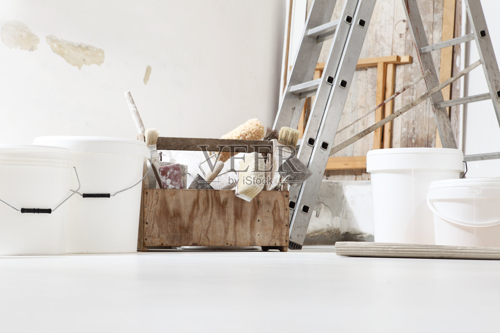 室内近距离拍摄正面的砖匠，抹灰或房屋油漆工工具在白色地板上与桶在家庭装修现场照片摄影图片