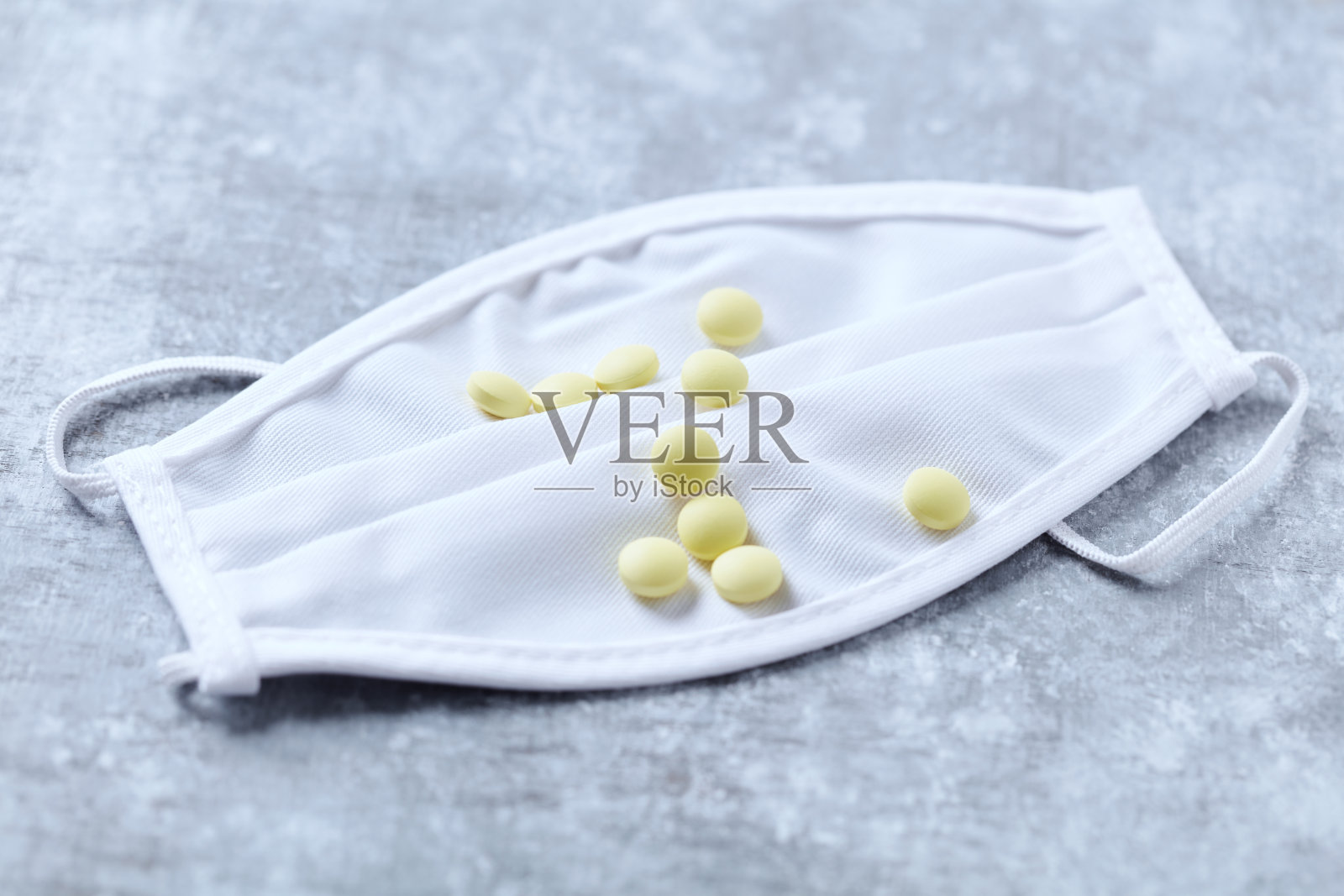 医用口罩上的维生素C片。明亮的木制背景。关闭了。照片摄影图片