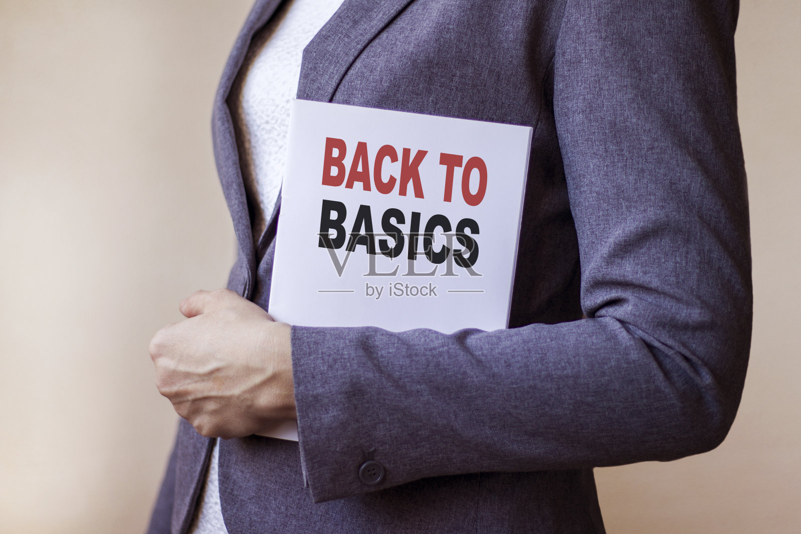 商务女性拿着一张卡片，上面写着“回BASIC”。经营理念。照片摄影图片