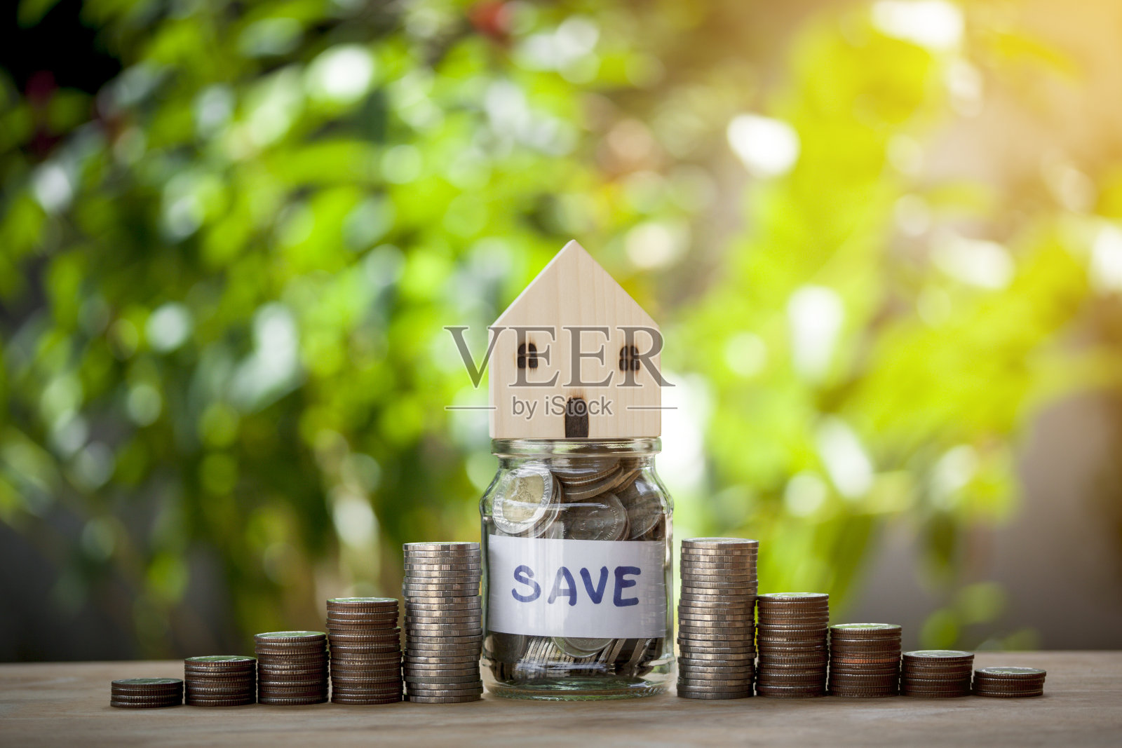 房子模型上有硬币和字，存钱在一个罐子里，为储蓄概念，投资，抵押，基金，金融和利率买房的未来和贷款散keh的背景。照片摄影图片