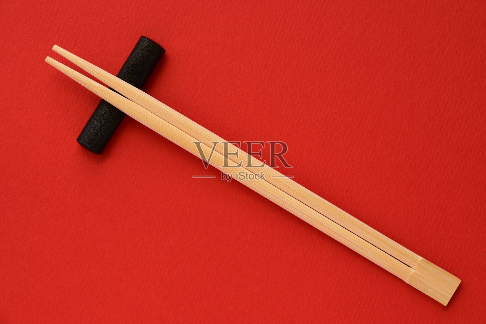 红色背景的一次性竹筷。照片摄影图片