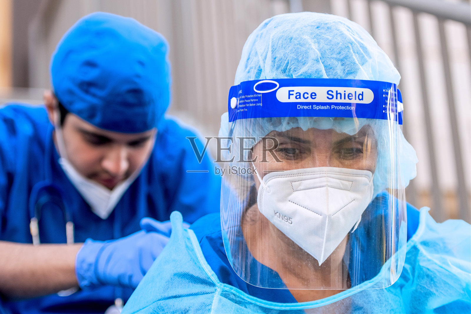 悲伤、沉思、过度劳累的医护人员坐着向下看照片摄影图片