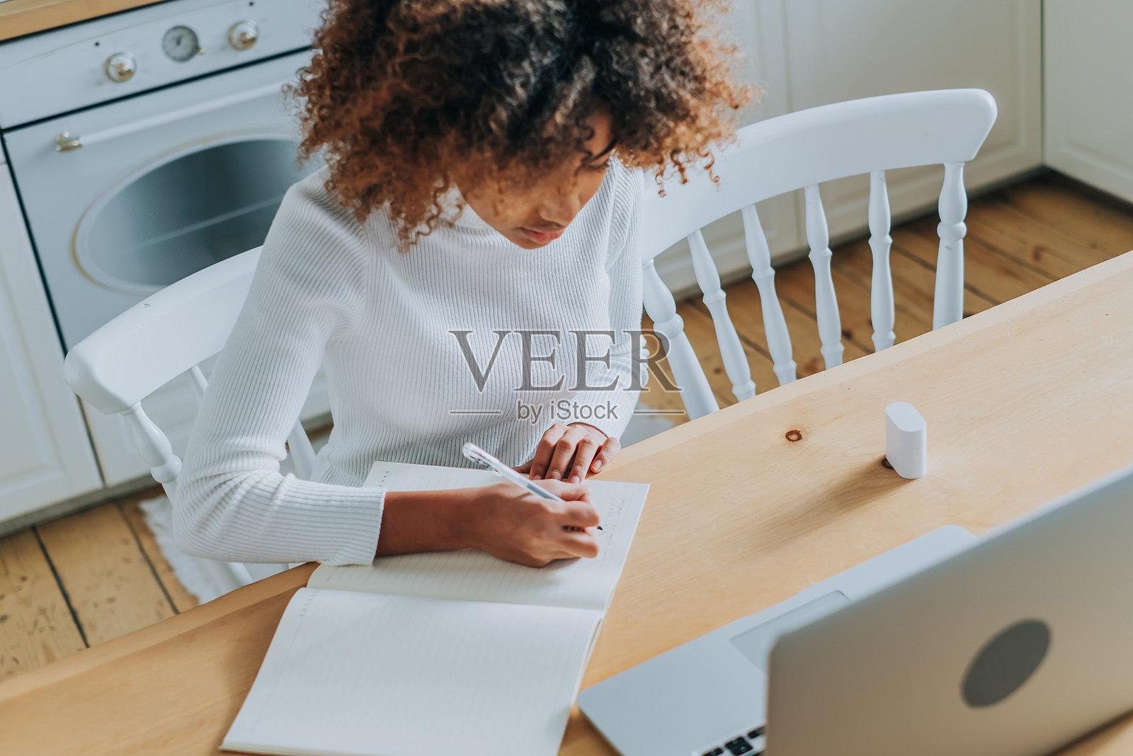 学生女孩坐在灰色笔记本和写笔记照片摄影图片